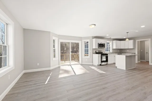 a view of kitchen with wooden floor and electronic appliances