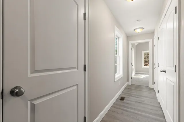a view of a hallway with wooden floor and closet