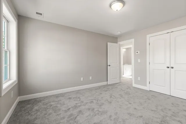 an empty room with windows and closet