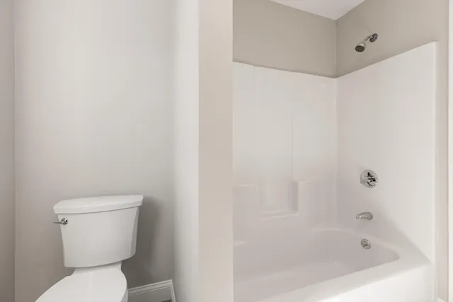 a white toilet sitting next to a bath tub