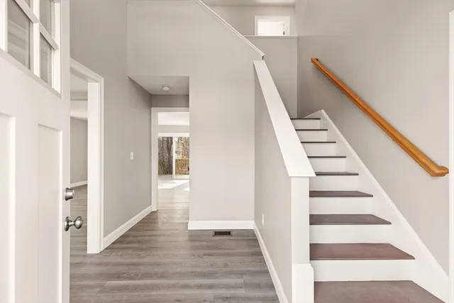 a view of a hallway with wooden floor and entryway