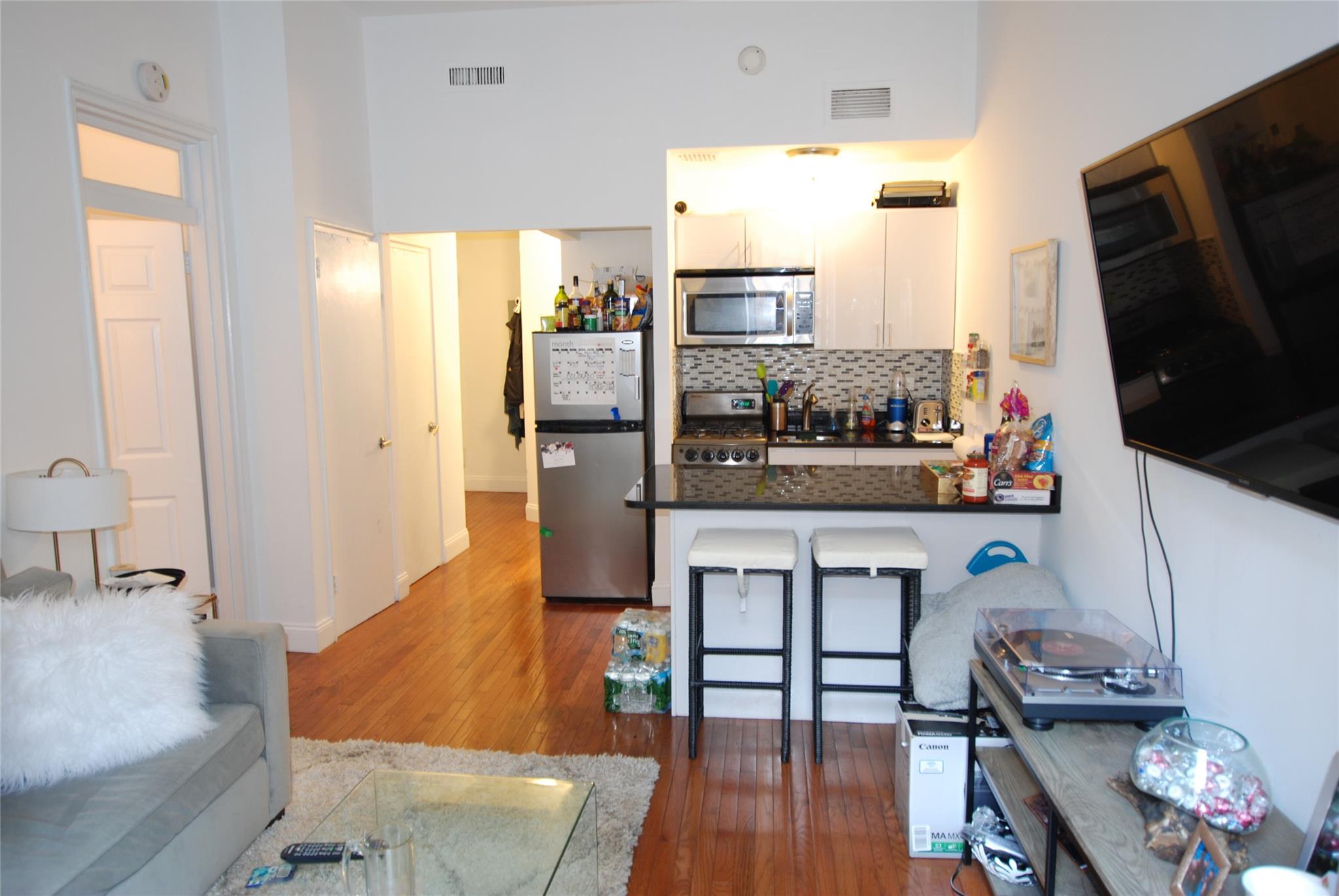 232 East 53rd Street Manhattan, NY 10022 - Photo 1 of 1 Living room with wood finished floors & Kitchen.