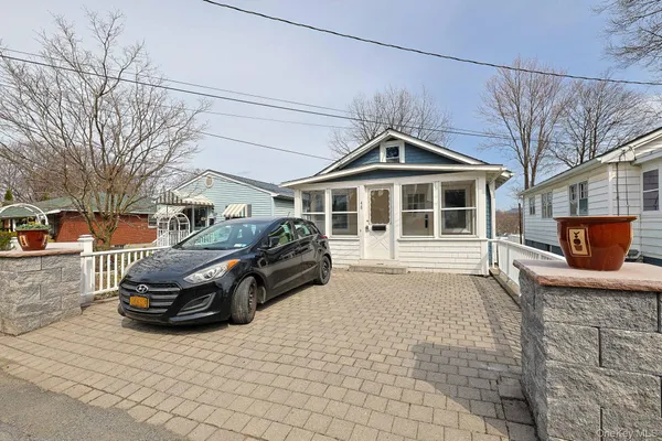a front view of a house with cars