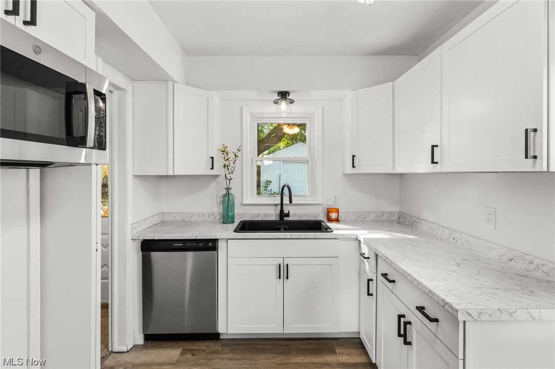 898 Reed Avenue Akron, OH 44306 - Photo 12 of 26 Kitchen featuring stainless steel appliances, light countertops, hardwood floors, and white cabinets