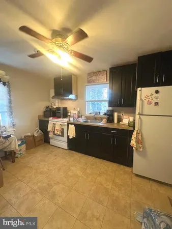 a kitchen with stainless steel appliances granite countertop a refrigerator a stove a sink and a white cabinets