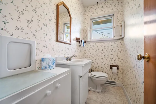 a bathroom with a granite countertop toilet sink and mirror