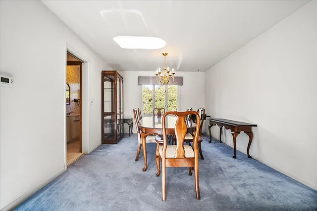 a view of a dining room with furniture and chandelier