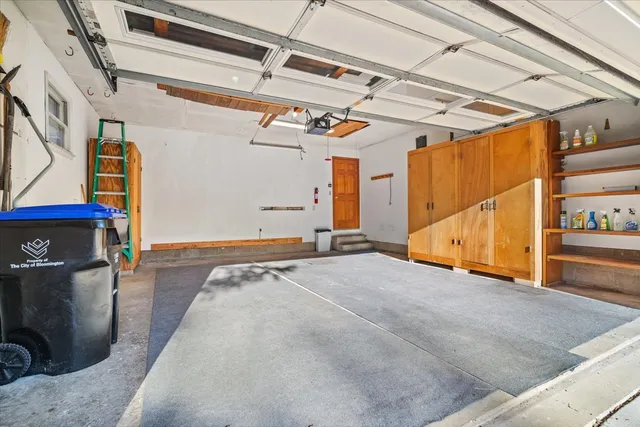 a view of a yard in front of a house with plants and large tree