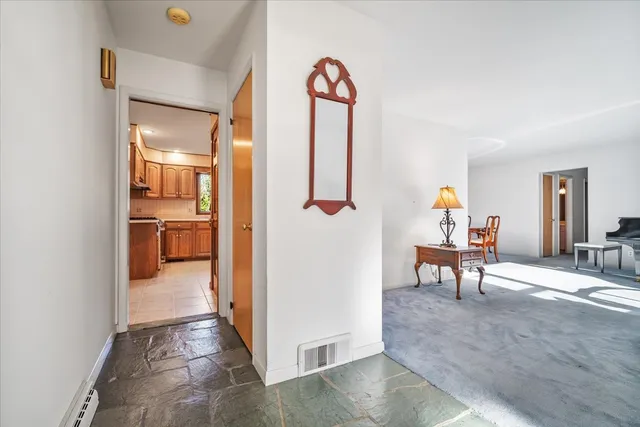 a view of a hallway with wooden floor and furniture