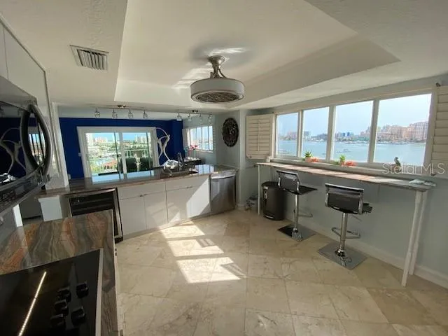 a kitchen with stainless steel appliances granite countertop a sink and a refrigerator