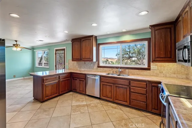 a large kitchen with stainless steel appliances granite countertop a sink and cabinets