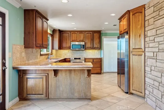 a kitchen with a sink window and stainless steel appliances