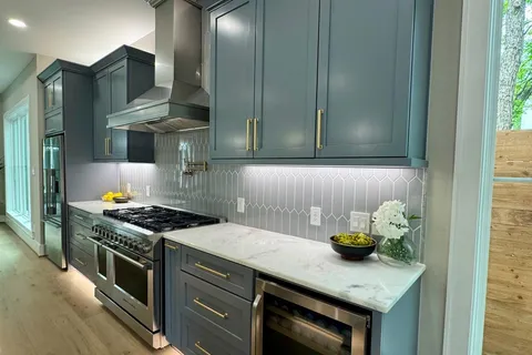 a kitchen with stainless steel appliances granite countertop a stove a sink and a microwave