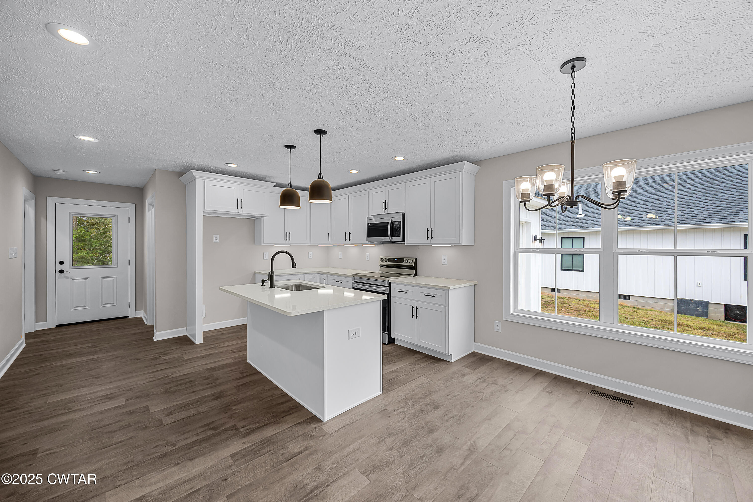 757 Christi Loop Henderson, TN 38340 - Photo 3 of 21 a large kitchen with kitchen island a large counter space a sink appliances and cabinets