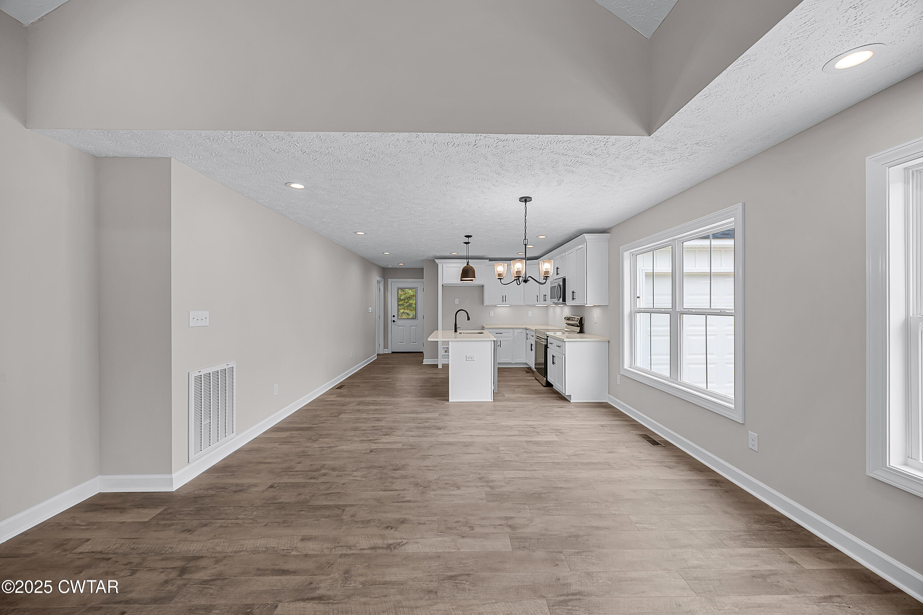 757 Christi Loop Henderson, TN 38340 - Photo 5 of 21 a view of a big room with windows and chandelier fan