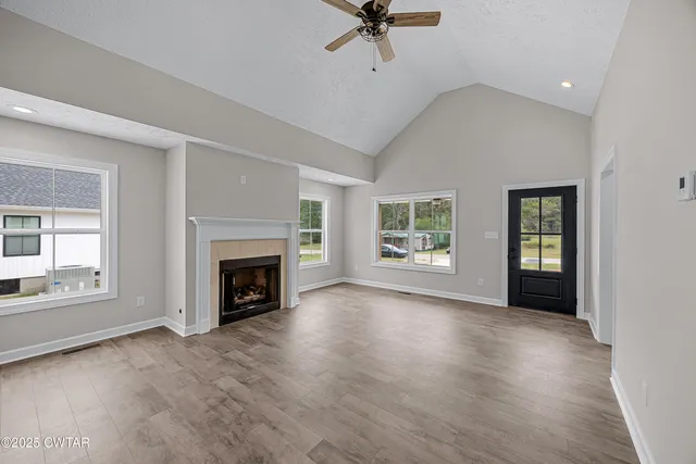 wooden floor fireplace and windows in an empty room