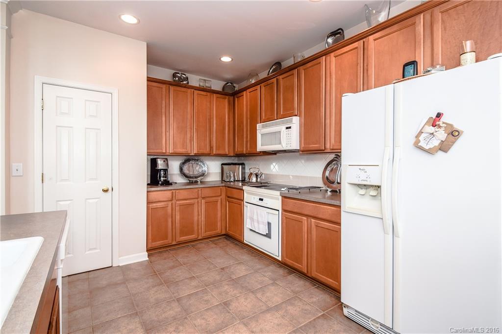 15739 Trenton Place Road Huntersville, NC 28078 - Photo 6 of 16 a kitchen with granite countertop a refrigerator and a stove top oven
