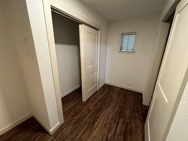 a view of a hallway with wooden floor and closet