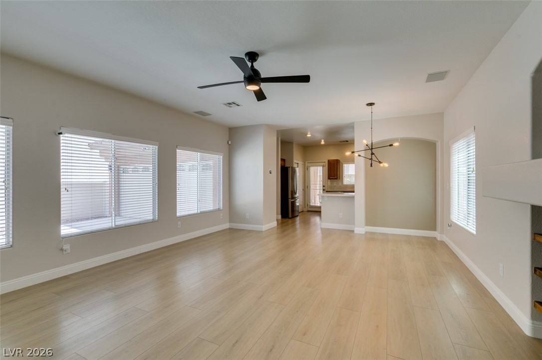 8909 Houston Ridge Avenue Las Vegas, NV 89178 - Photo 3 of 45 Hardwood-style flooring extends across an airy living space with abundant natural illumination and a contemporary ceiling fan.