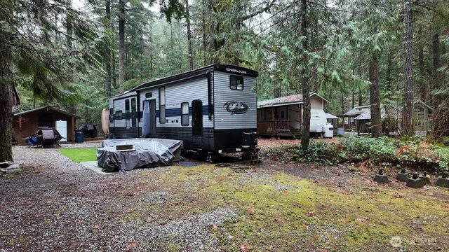 a front view of a house with a yard and trees