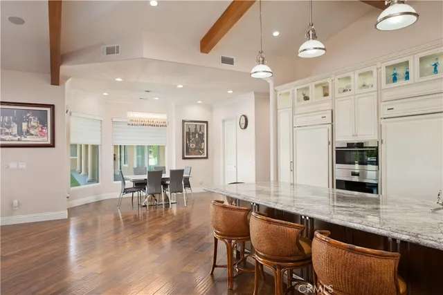 a large kitchen with stainless steel appliances granite countertop a stove a sink dishwasher and a refrigerator with wooden cabinets