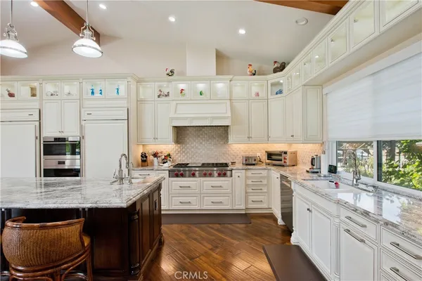 a view of a hallway with wooden floor and a bathroom