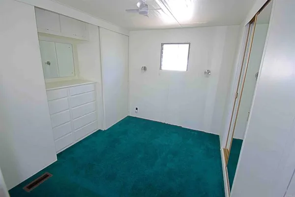 an empty room with closet and mirror