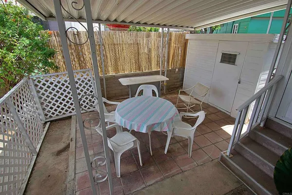 a view of a chairs and table in the back yard of the house