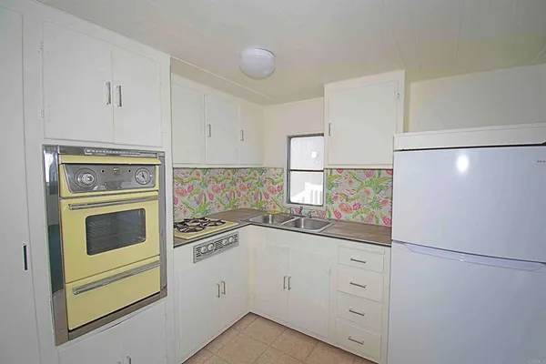 a kitchen with white cabinets and white appliances