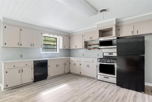 a kitchen with granite countertop a refrigerator stove and sink