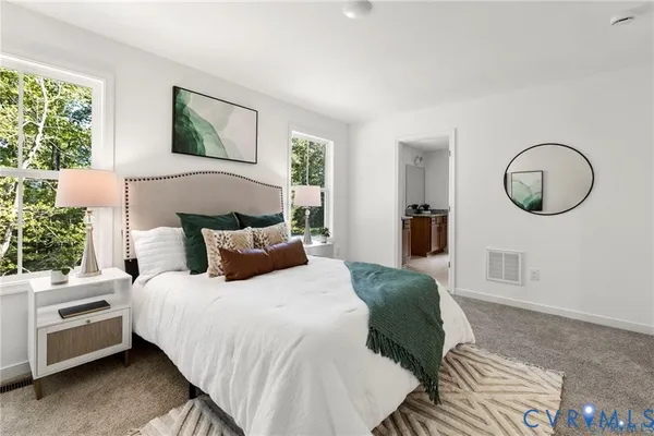 a bedroom with a bed mirror and a window
