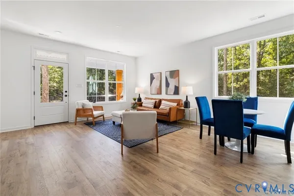 a living room with furniture and a wooden floor