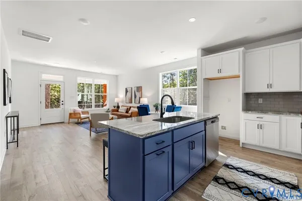 a kitchen with granite countertop a sink stove and cabinets