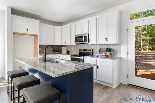 a kitchen with stainless steel appliances granite countertop a sink stove and cabinets