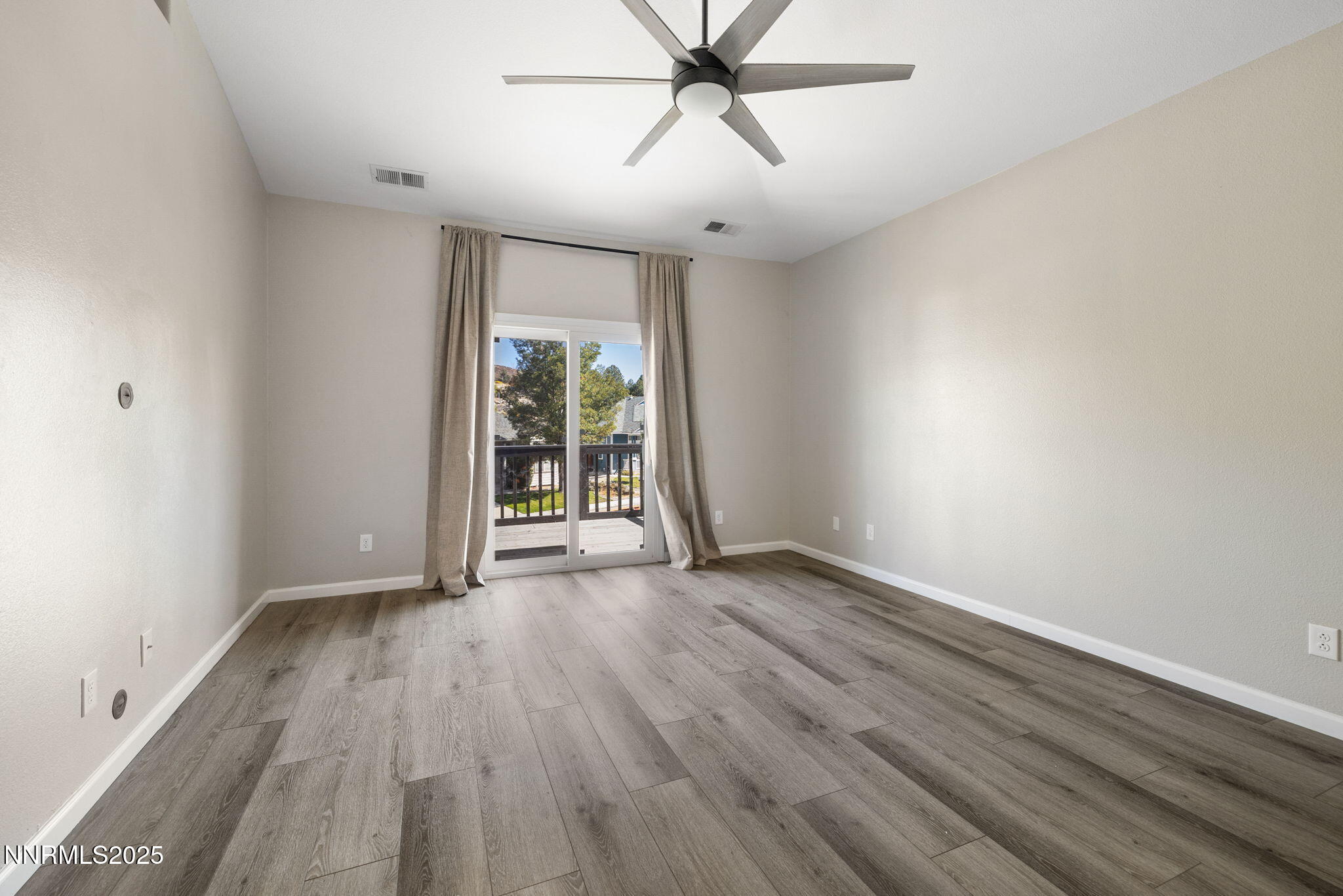7510 Michaela Drive Reno, NV 89511 - Photo 16 of 33 an empty room with wooden floor and windows
