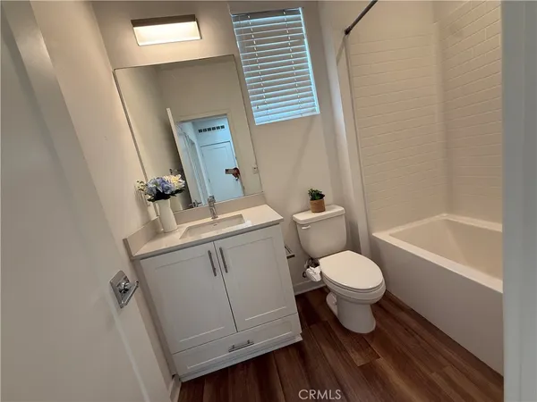a white toilet sitting next to a bathroom sink and vanity