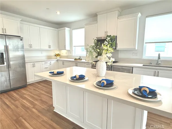 a kitchen with white cabinets and appliances