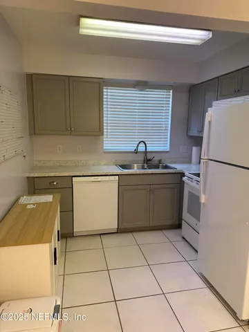 a kitchen with a sink a refrigerator and a stove top oven