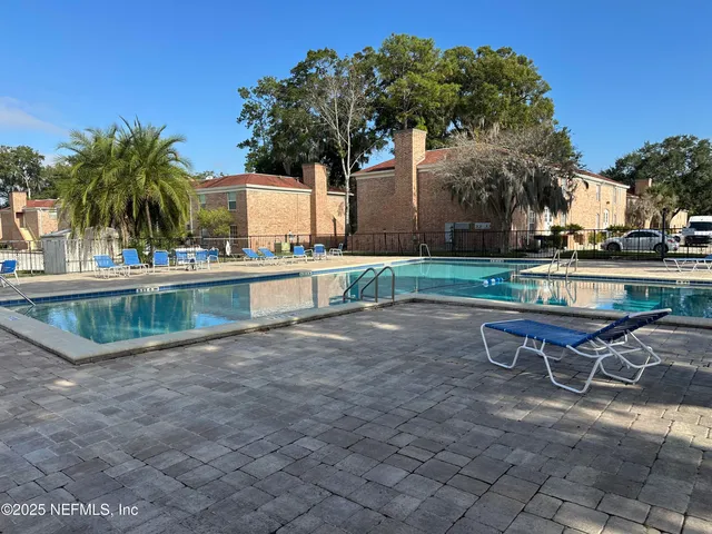 a view of a swimming pool with a patio and a yard