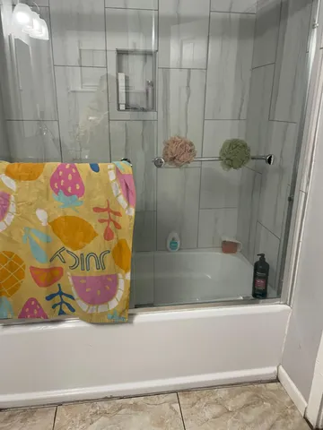 a bathroom with a tub shower and sink