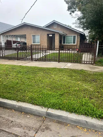 a front view of a house with a garden and yard