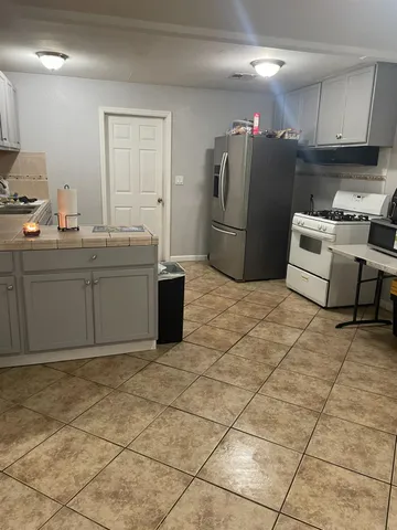a kitchen with refrigerator and cabinets