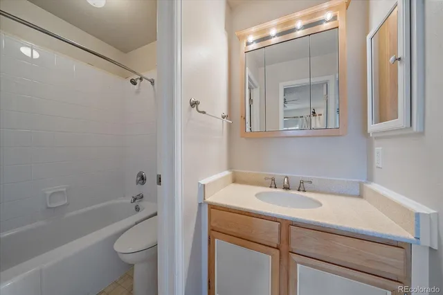 a bathroom with a sink toilet vanity tub and shower