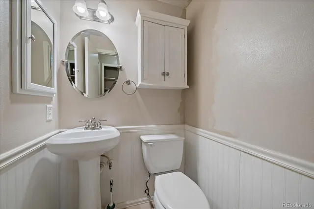 a bathroom with a toilet sink and mirror