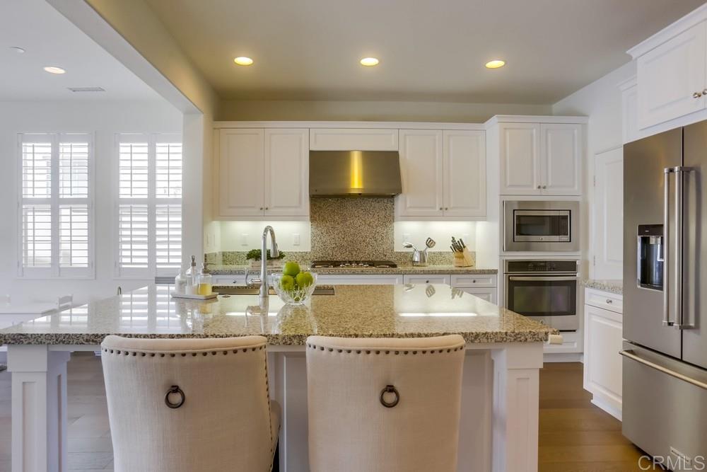 13416 Red Oak Way San Diego, CA 92130 - Photo 7 of 24 a kitchen with stainless steel appliances granite countertop a sink stove and refrigerator