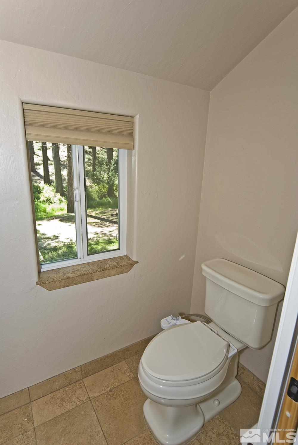 130 Sawmill Road Markleeville, CA 96120 - Photo 21 of 32 a white toilet sitting next to a window in a bathroom