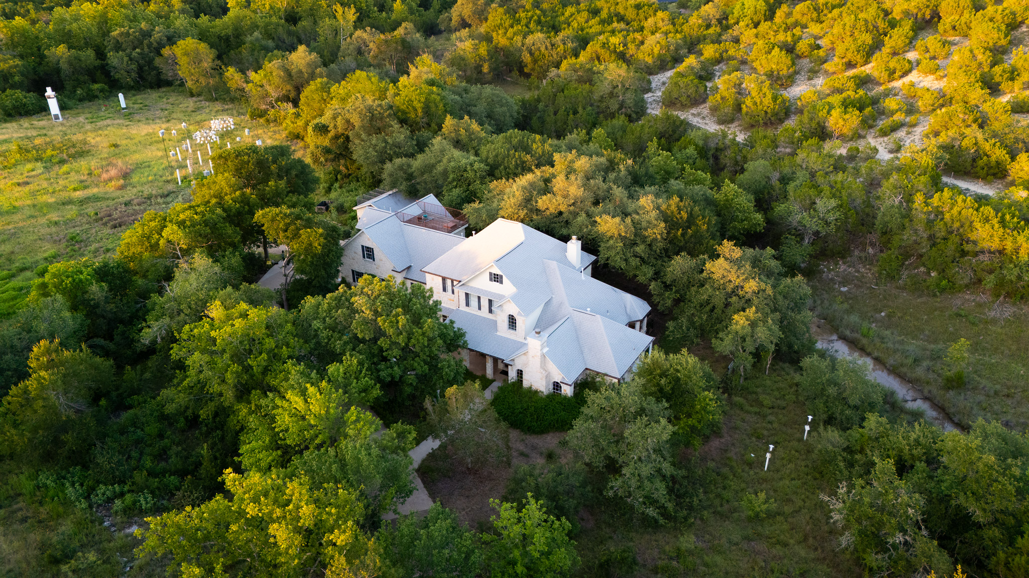 13800 Lone Rider Trail Austin, TX 78738 - Photo 1 of 32 Perched amidst a verdant landscape, this estate offers a secluded retreat with lush surroundings.