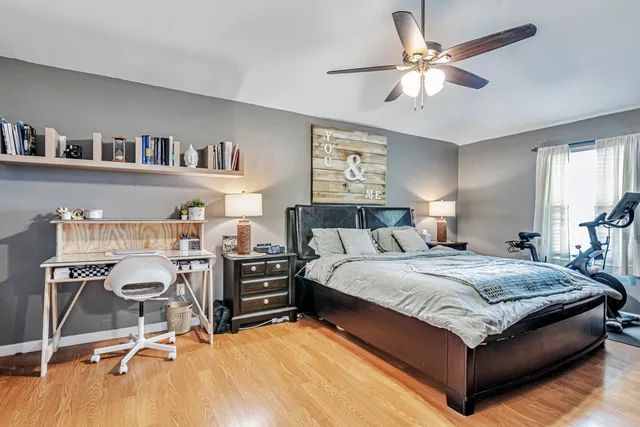 a bedroom with a bed a desk and book shelfs