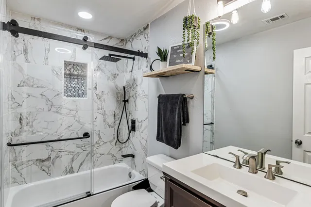 a bathroom with a sink toilet and shower