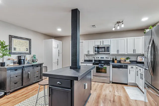 a kitchen with stainless steel appliances granite countertop a sink stove and refrigerator